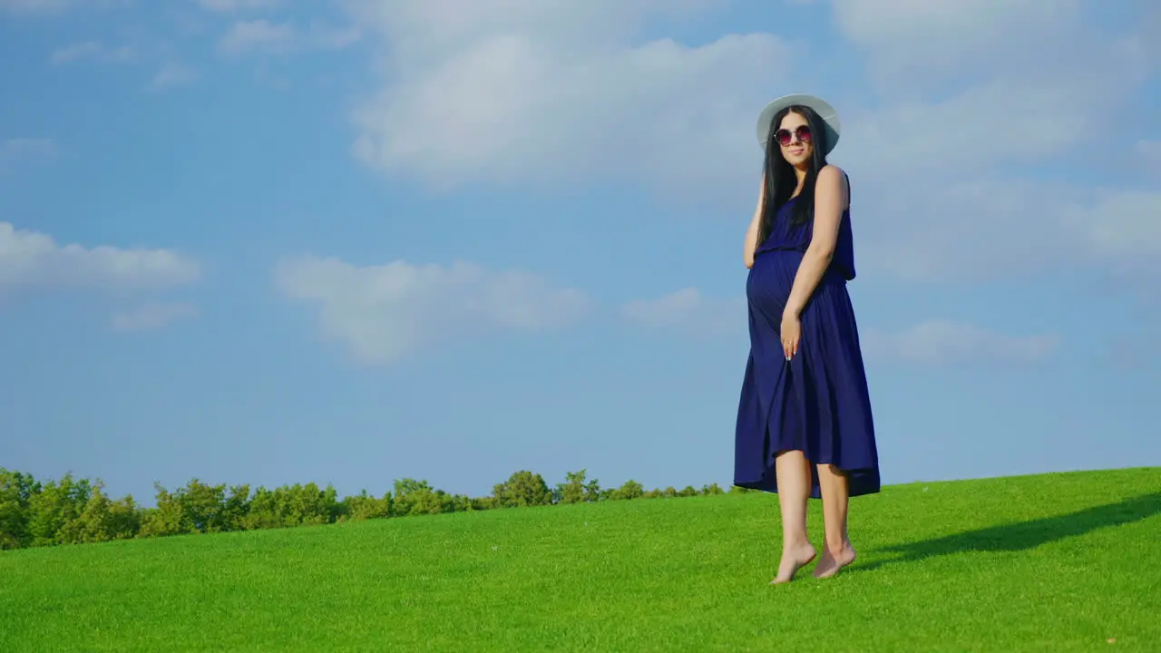 A Stylish Woman In A Hat And Sunglasses Waiting For A Child