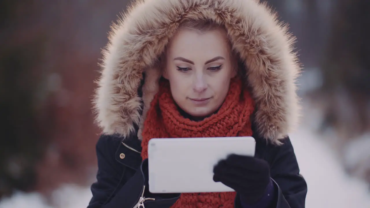 Female Tourist Using Digital Tablet In Forest In Winter 1