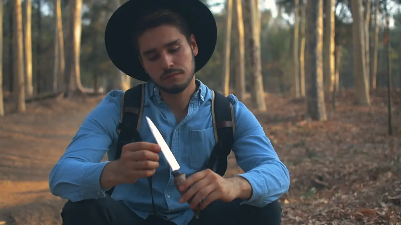 Explorer in the woods playing with a knife