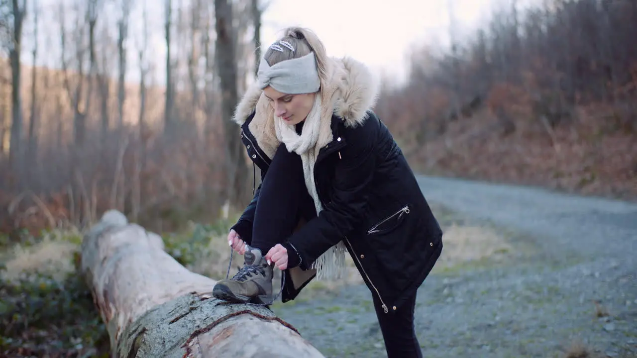 Beautiful Female Tourist Tying Shoe On Mountain Trail 1