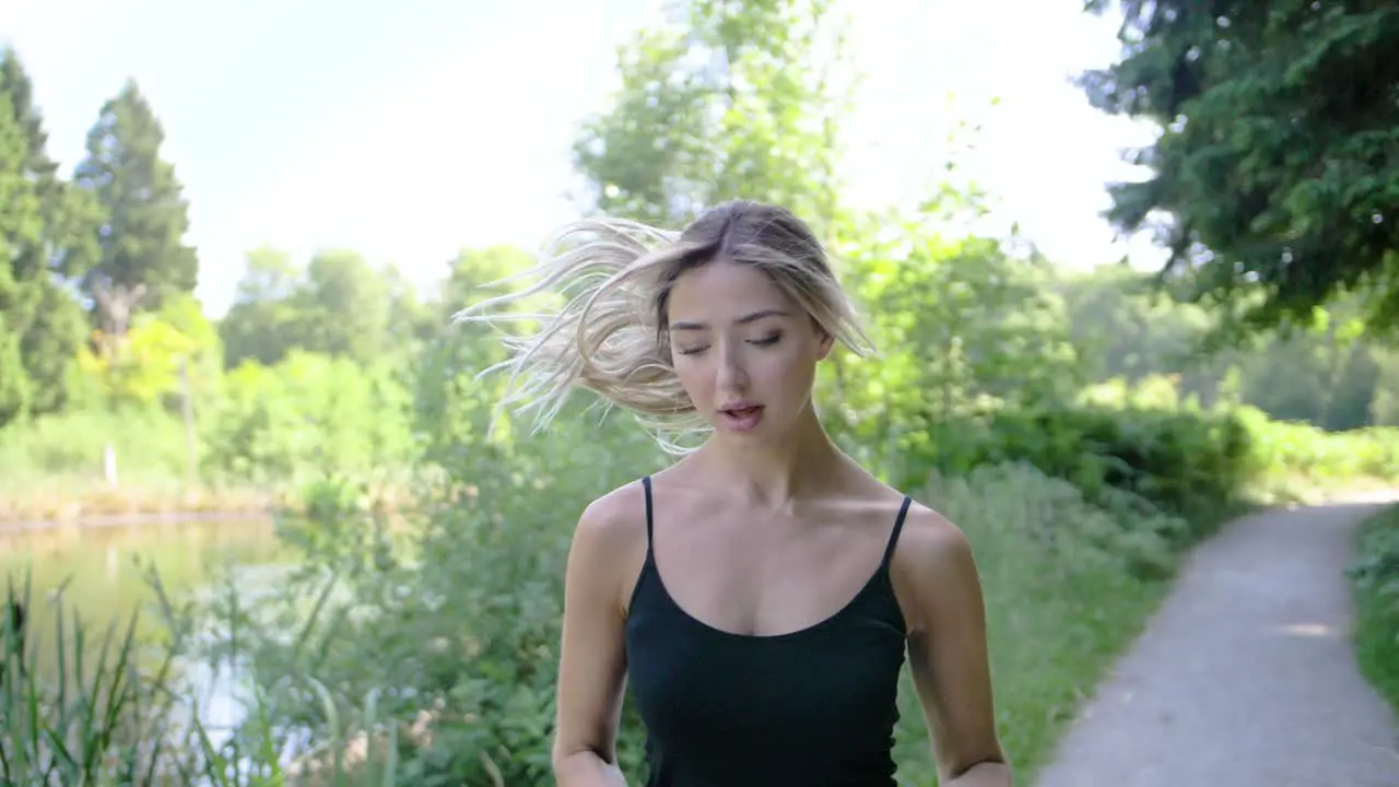 A woman jogs in a park on a perfect summer day