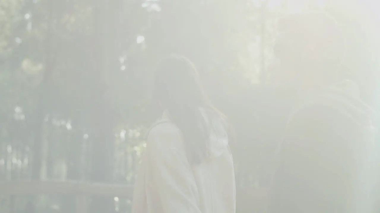 Young Couple Walking In Park Enjoying Sunny Day