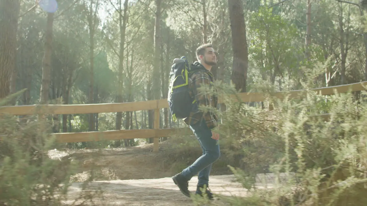 Bearded Young Male Backpacker Walking Alone In The Forest