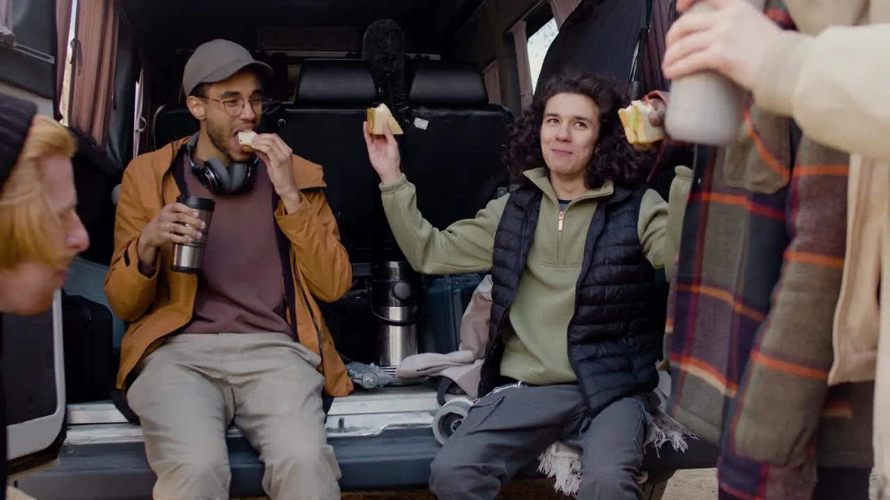 A Movie Production Team Taking A Break While Eating A Sandwich And Talking Behind A Van In The Street 4