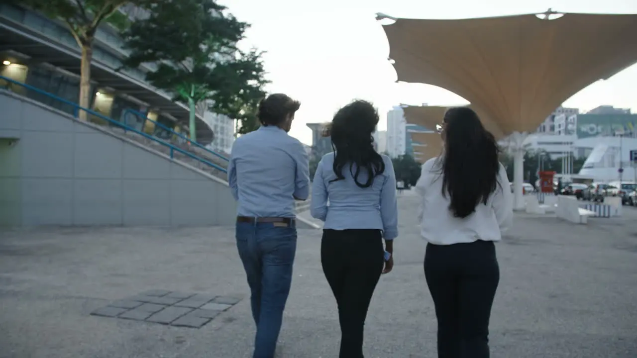 Back View Of Three Young Business People Walking In Same Direction Talking