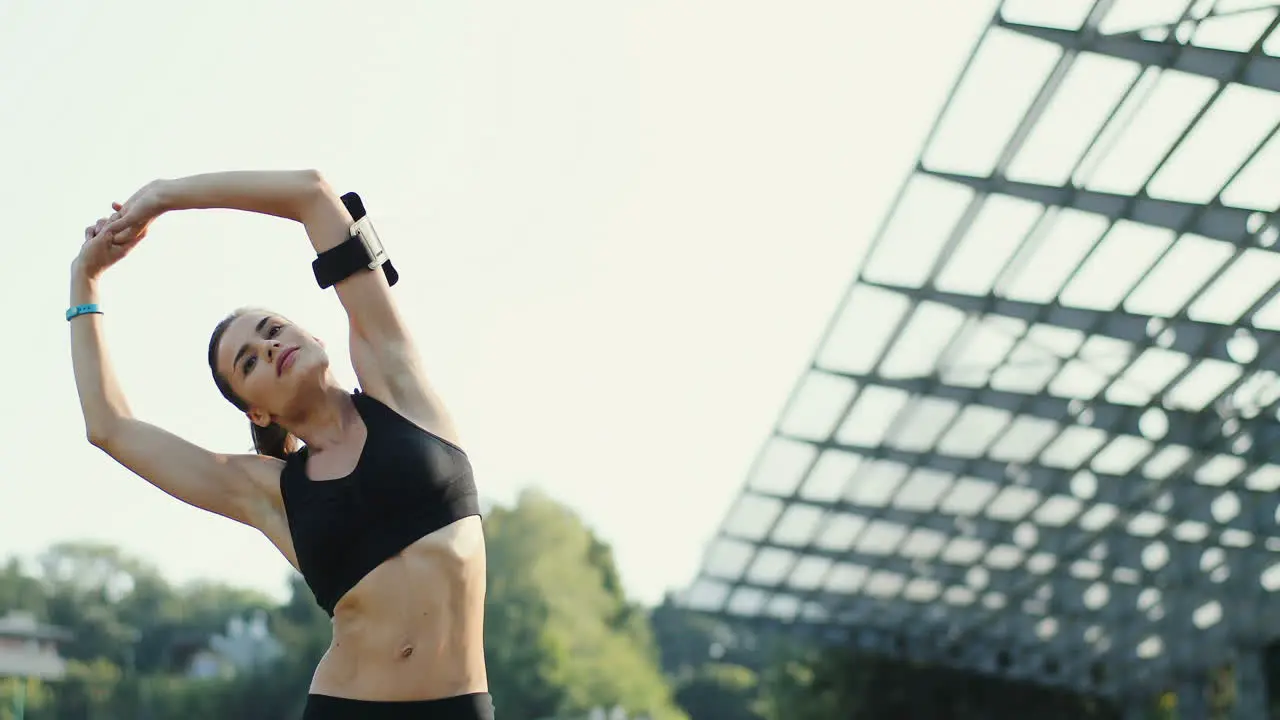 Young Jogger Woman Training And Warming Up Hands And Shoulders In The Stadium In Summer