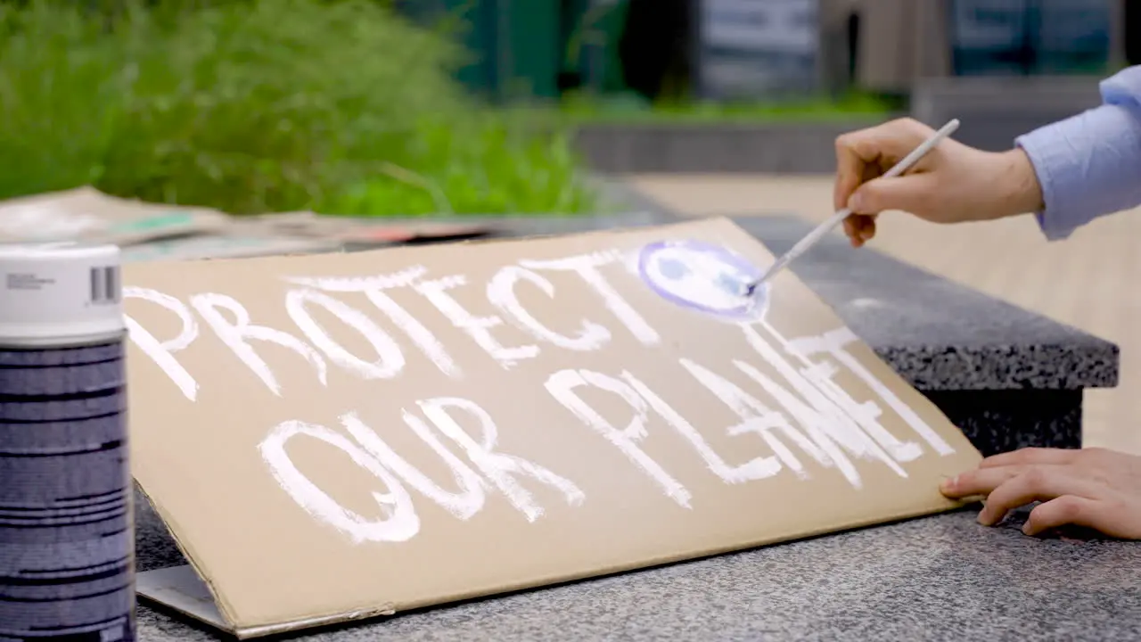 Close Up Of Hands Painting A Placard