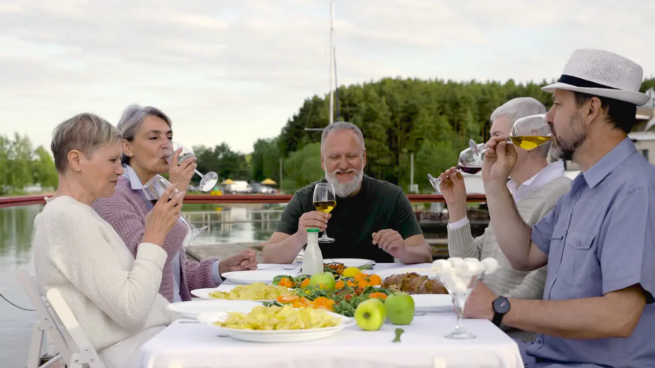 A Gorup Of Senior People Toasting And Drinking Before Having Dinner