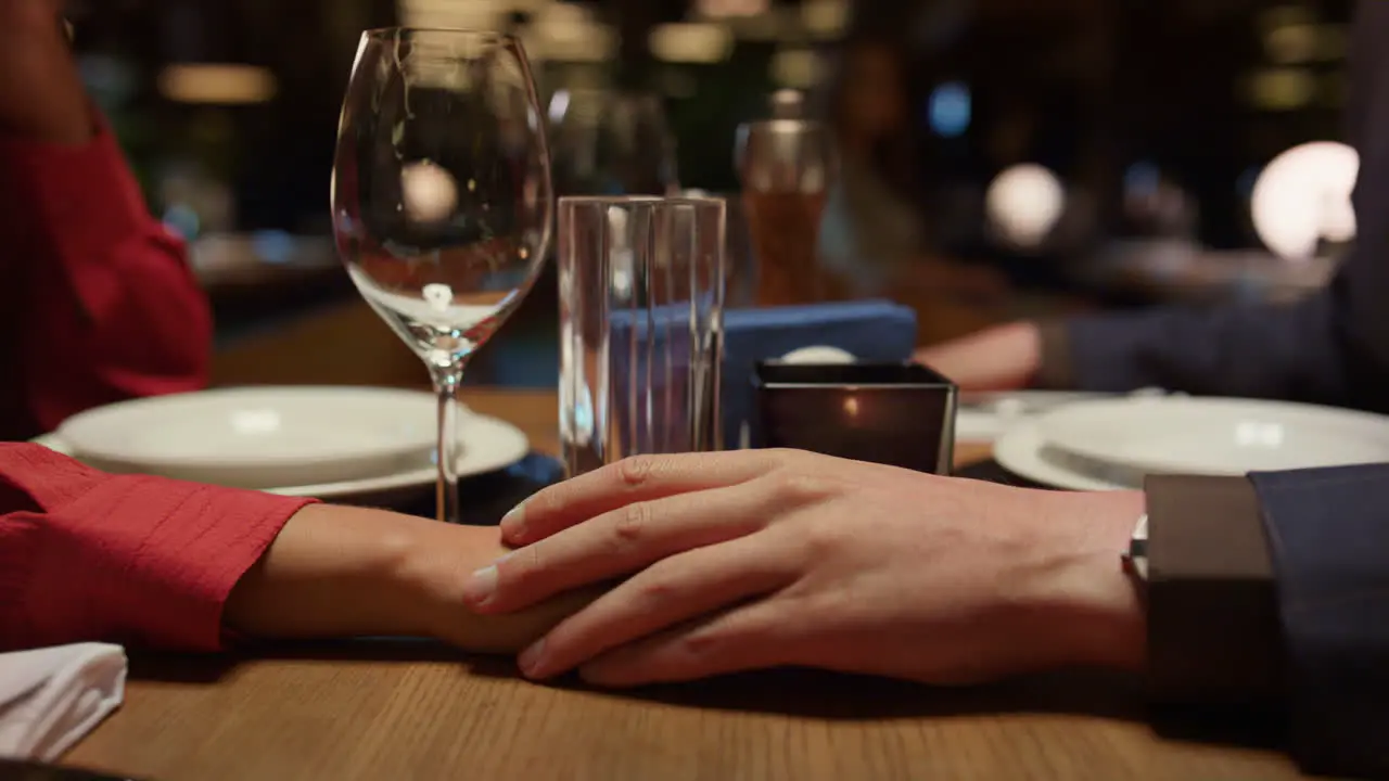 Romantic couple holding hands in luxury interior restaurant Dating concept