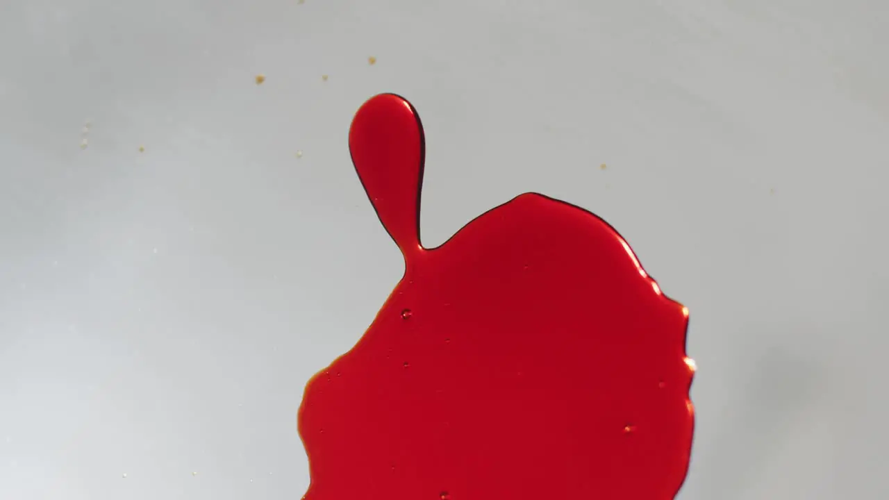 Video of red blood stains falling on white background