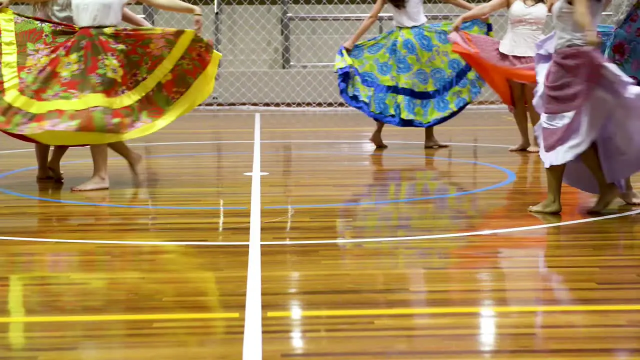 Women dancing in a presentation with colorful long round skirts