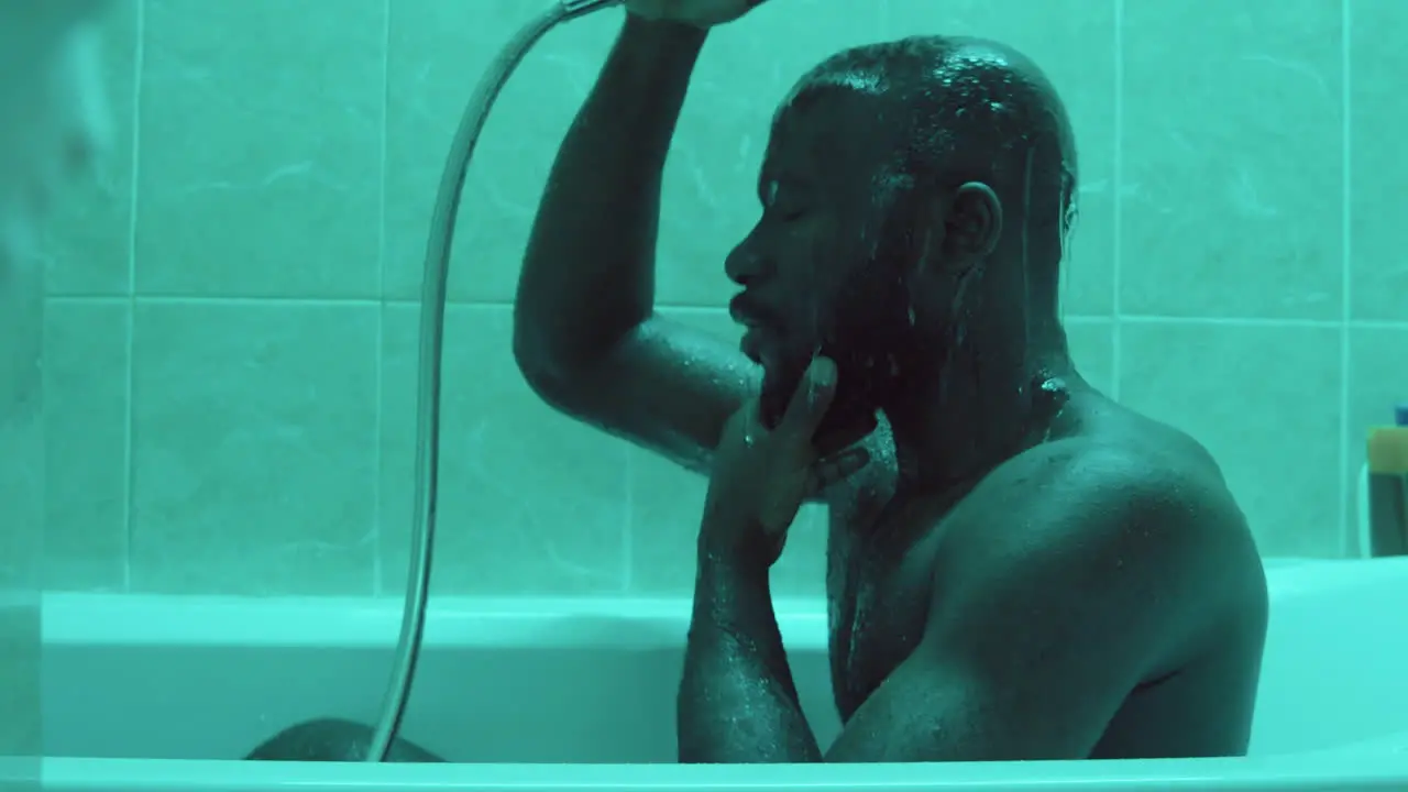 African American Man Showering in Bathtub