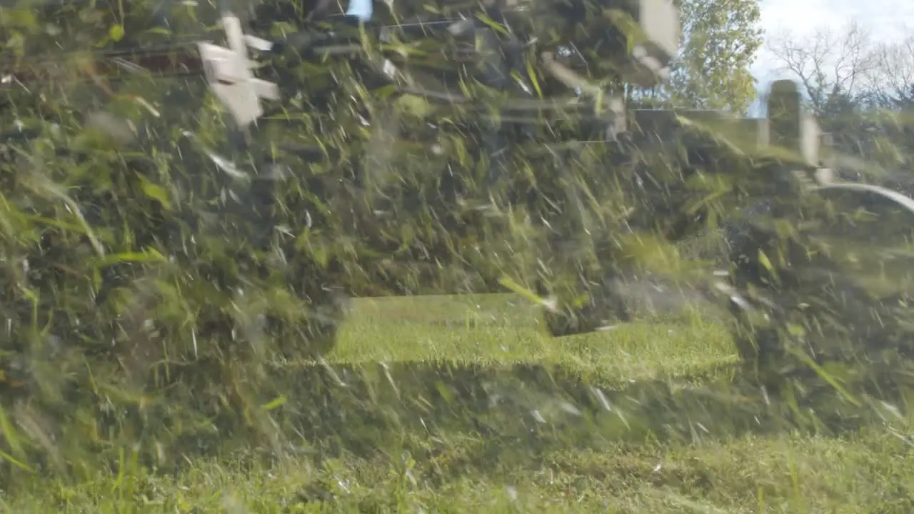 White person on lawn tractor mowing a lawn in rural America low angle