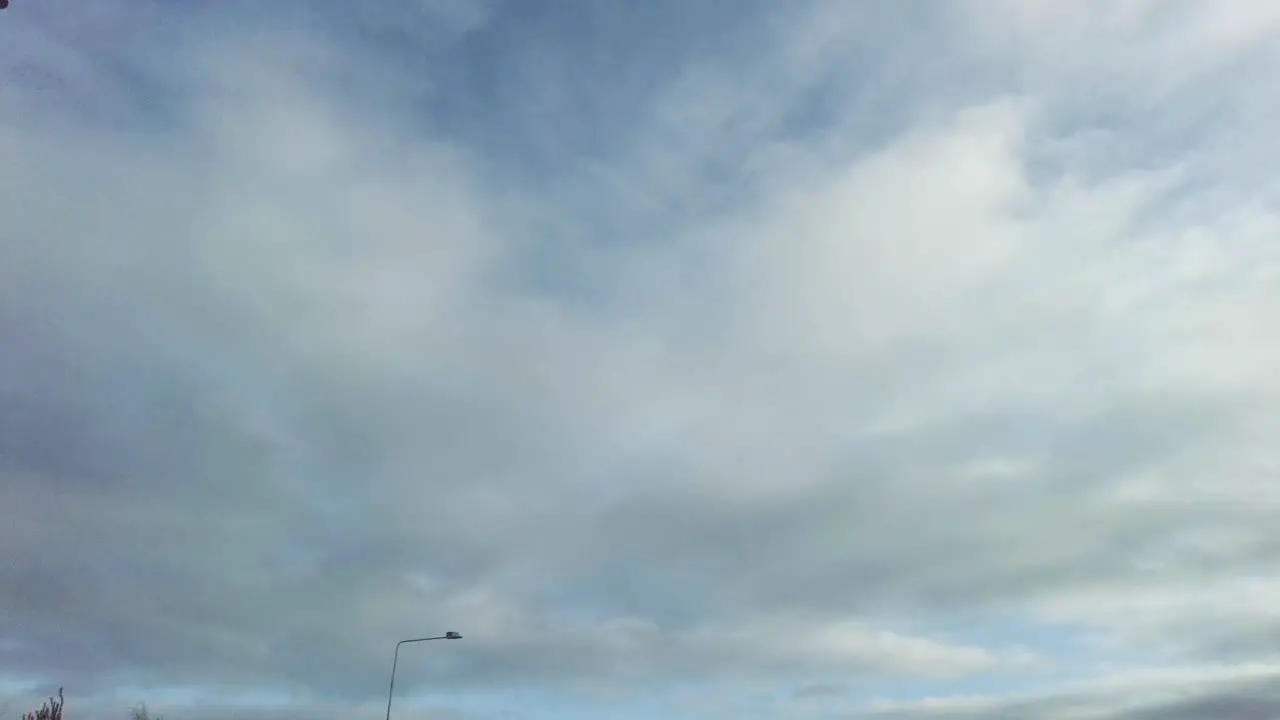 Sky motion on a road with lamp standards passing by showing speed