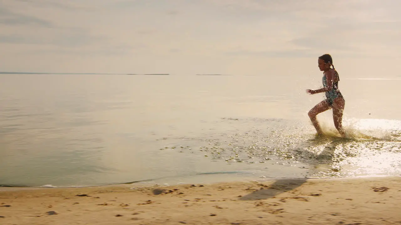 Carefree Girl Of 7 Years Running On The Water From Her Feet Flying A Lot Of Splashing Slow Motion