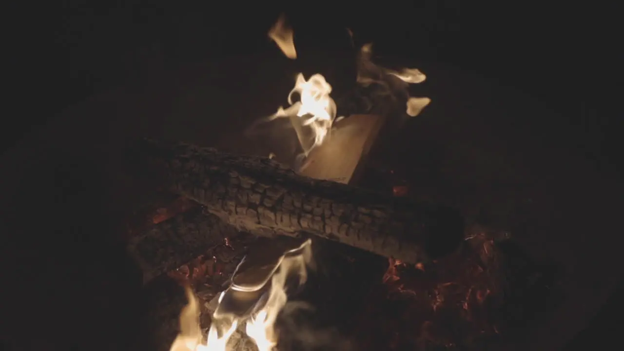 Panning motion shot of logs burning in a fire pit