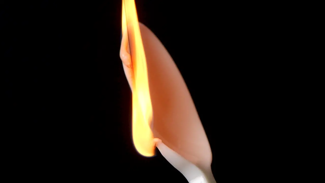 Flame burns isolated plastic spoon against black background