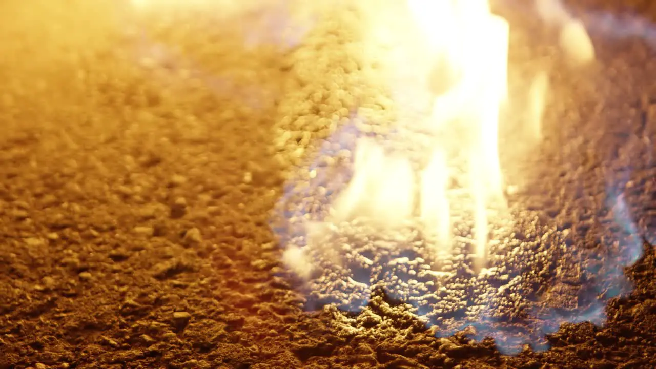 Close up shot of a hand with a lighter set fire flame on the ground on a road street at night 25p