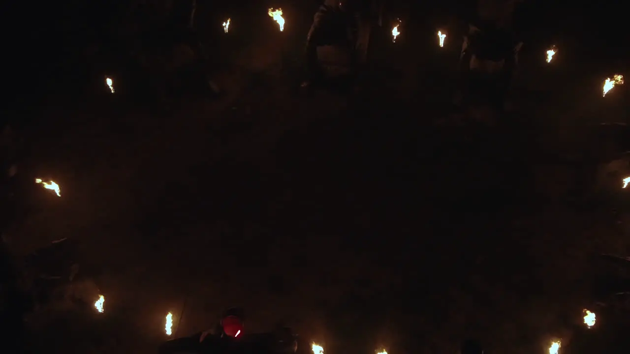 Panning down shot revealing a circular statue monument with fire torches