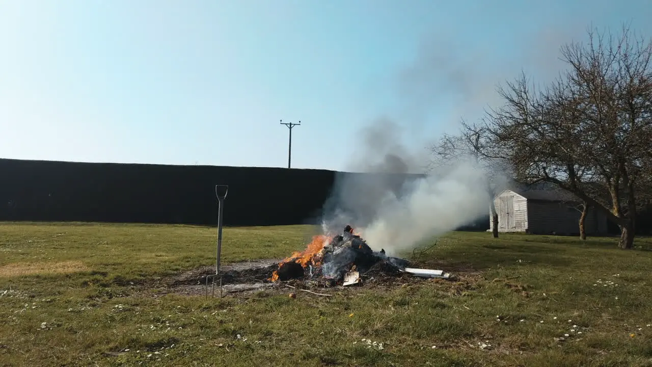 TIMELAPSE PAN OF GARDEN BONFIRE AS IT BURNS WOODEN PALLETS