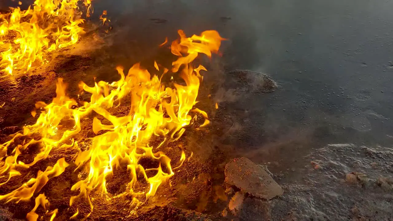 Oil spill caught on fire slowly burns and melts the surrounding snow