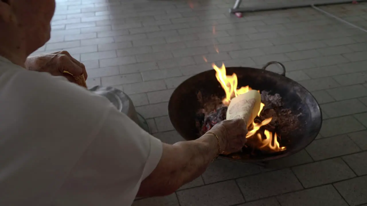 close-up shot on hand put joss paper into the flame