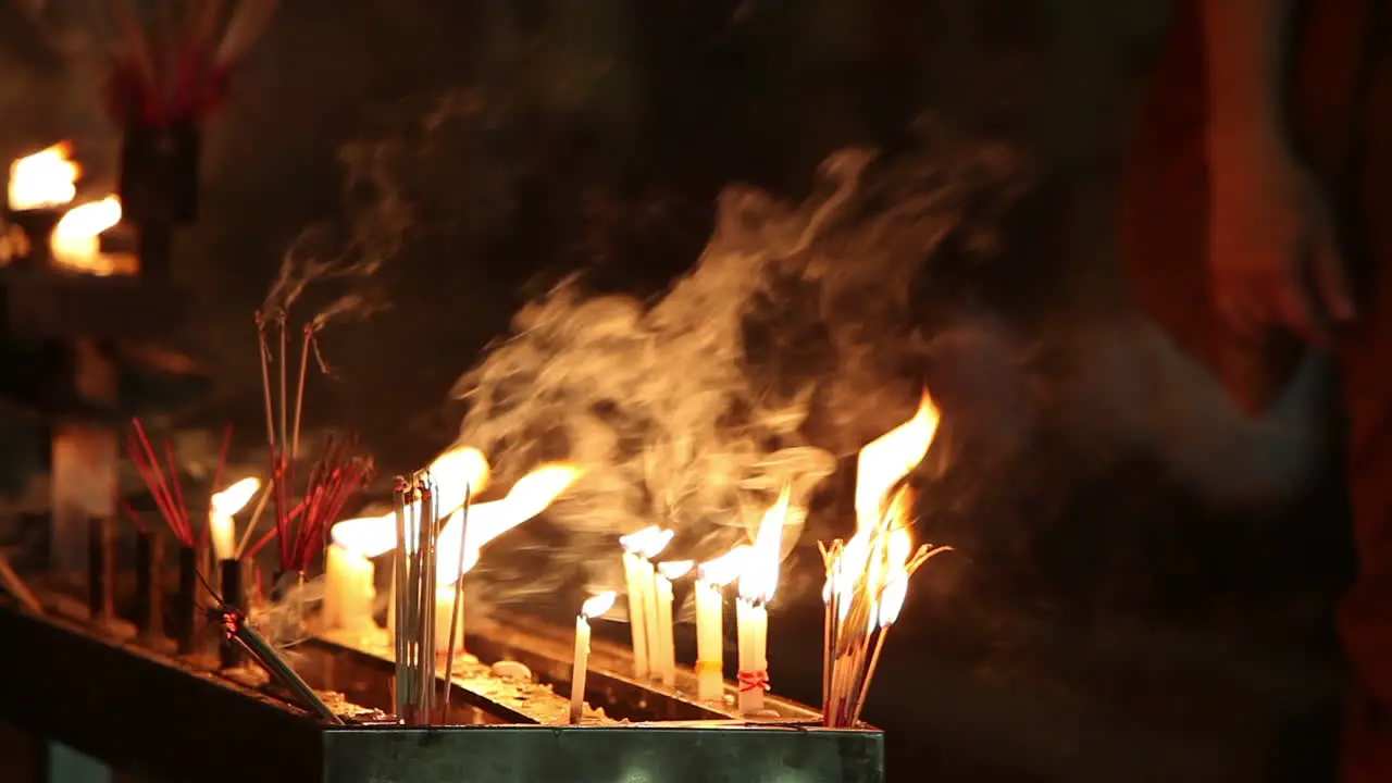 Prayer candles burn at a Burmese temple