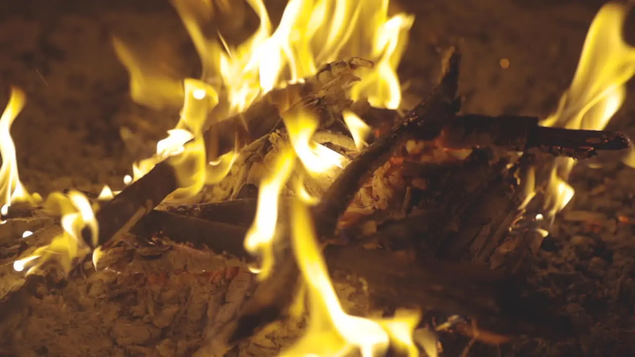 Panning motion shot of sticks burning in a fire pit