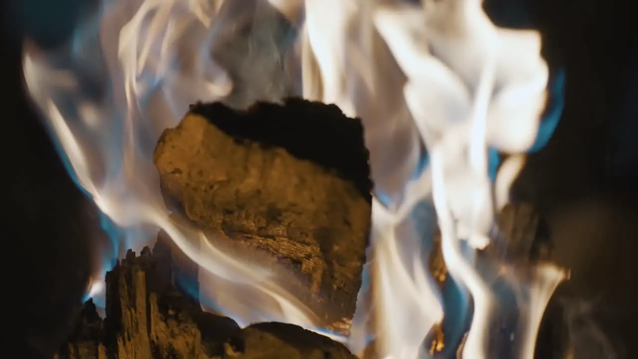 close-up of the log burning with flames in slow-motion during a campfire