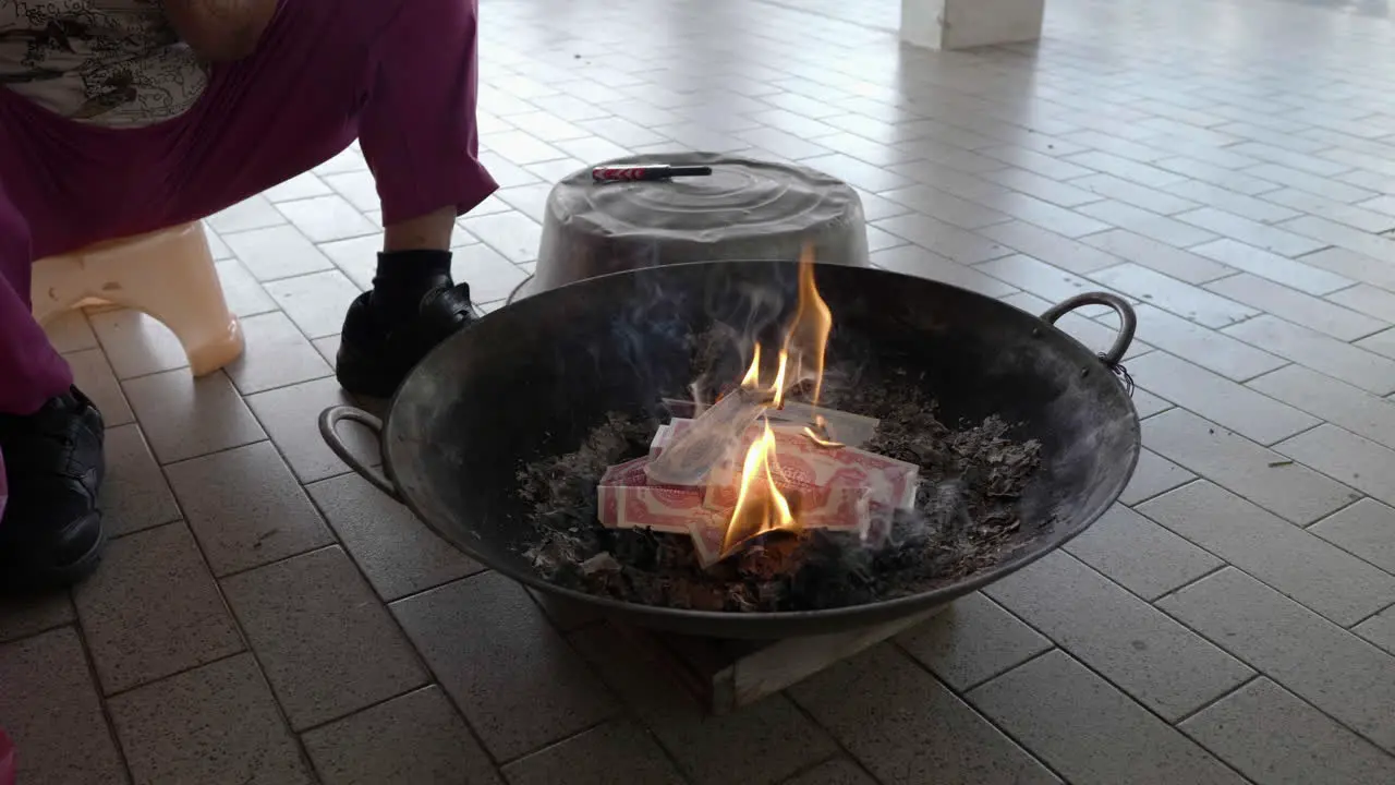 close-up shot put joss paper into the flame