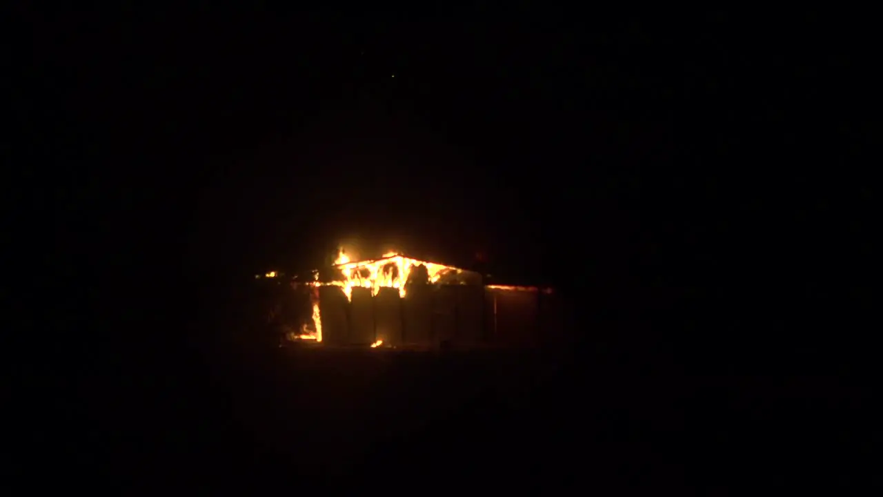 A distant building burns at night during the 2017 Thomas fire in Ventura County California