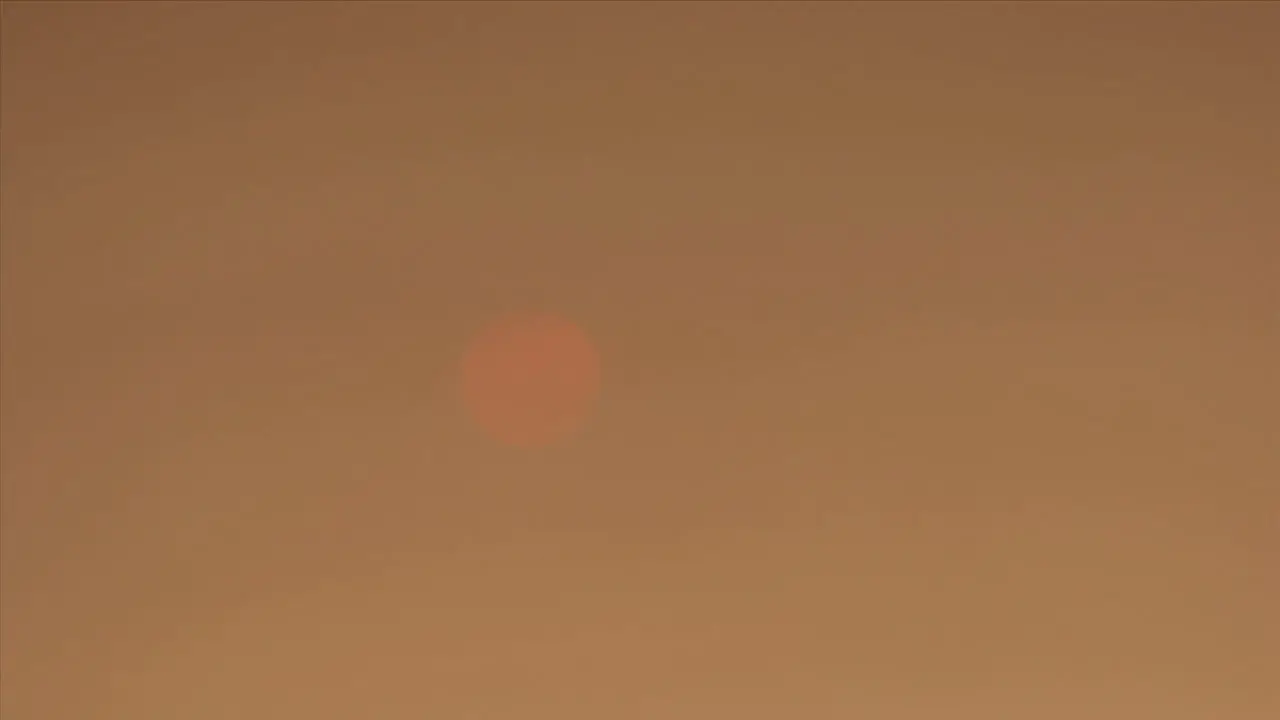 A smoky haze covers the sun