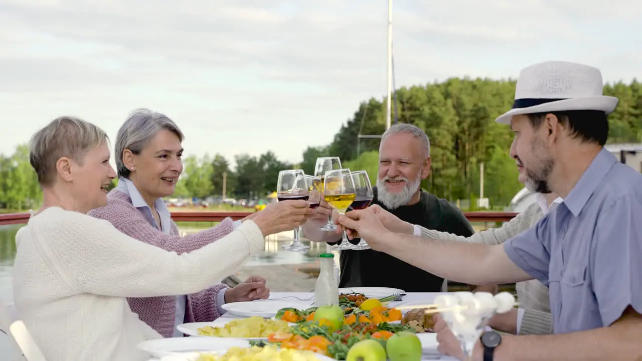 A Group Of Senior People Are Having Dinner Toasting And Drinking