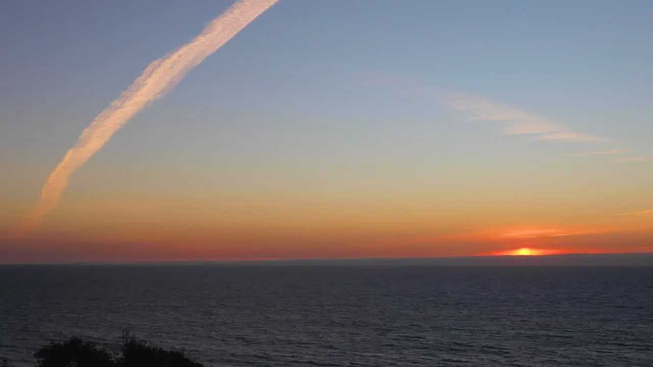 Sunset timelaps with the ocean and airplane clouds