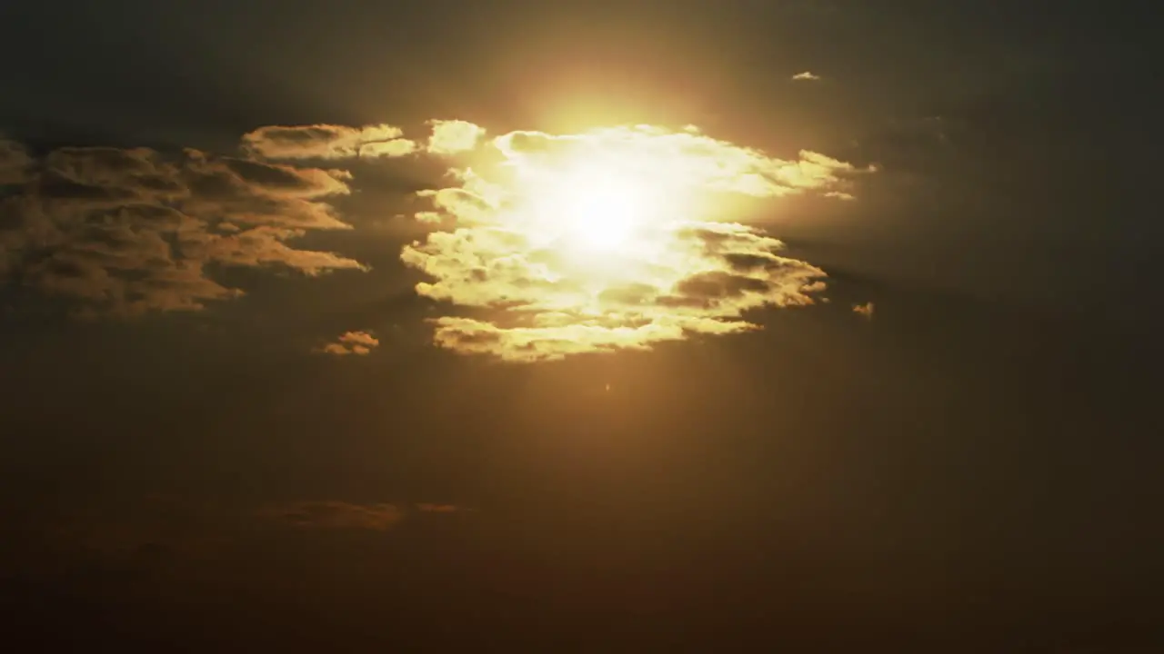 Sunset time lapse with the golden sun behind a dynamic cloudscape at dusk