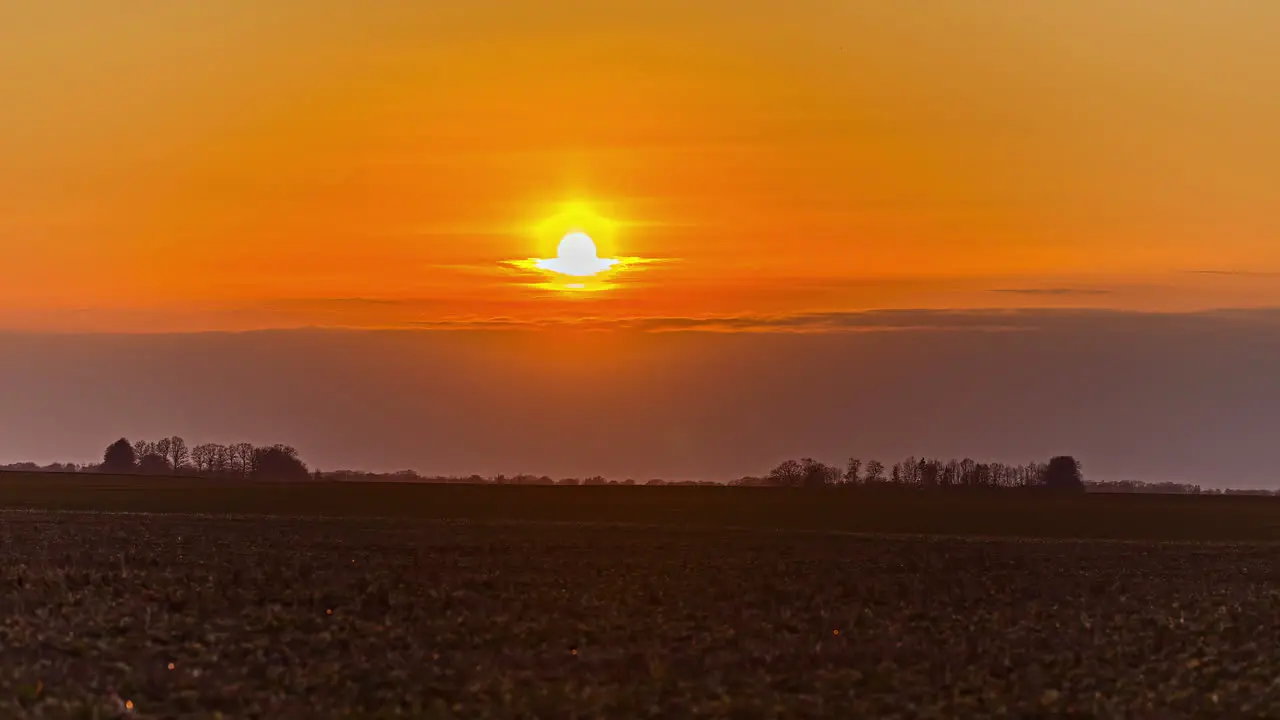 Timelapse of sunset in a vast empty meadow in the golden hour with no people