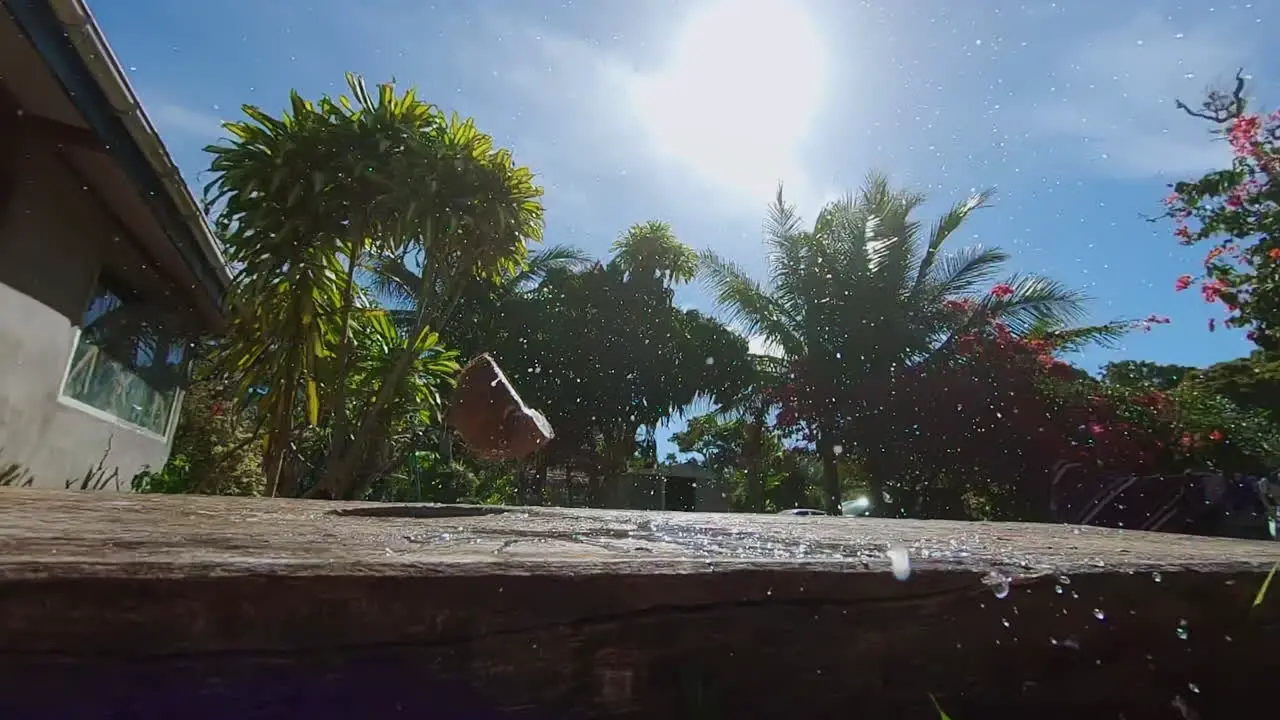 Water splashes out of fresh coconut after hitting wooden table