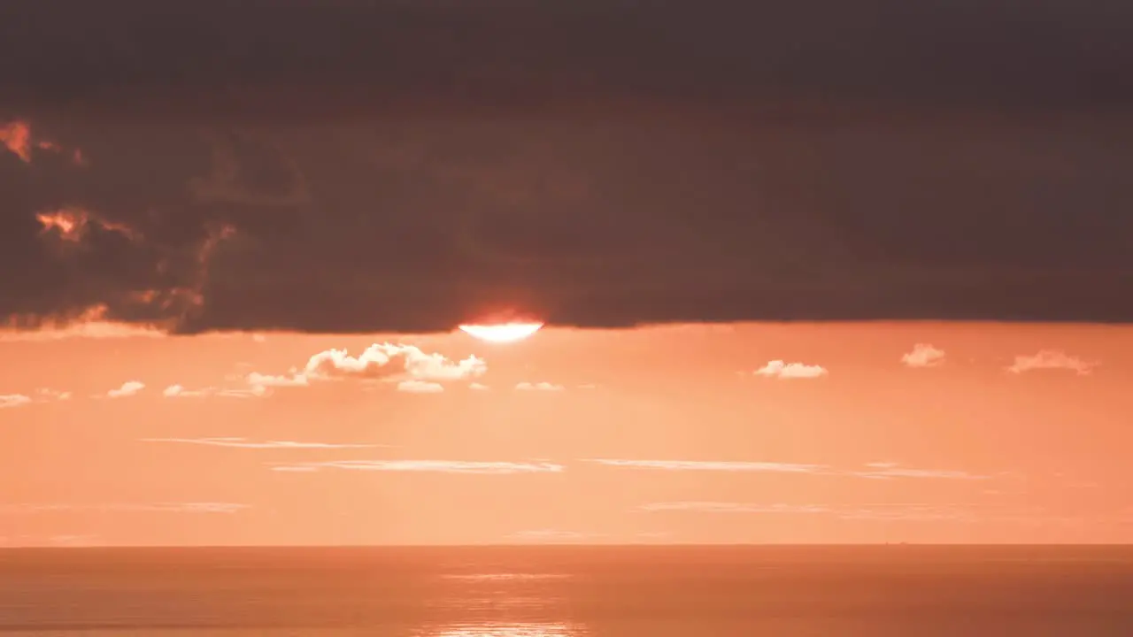 The sun sets in a huge orange ball in time lapse 1