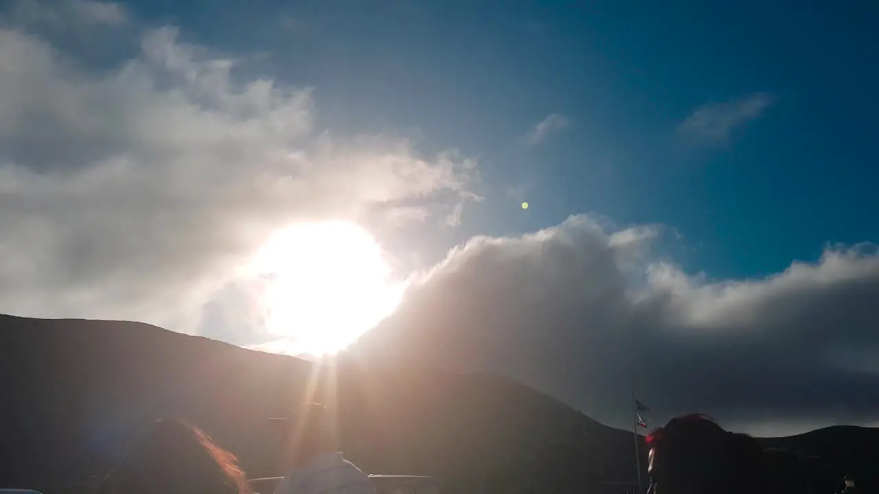 Clouds slowly passing over hill with sun behind them at Golden Gate Bridge View on Marin Headlands San Francisco California USA