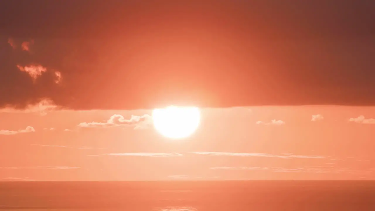 The sun sets in a huge orange ball in time lapse