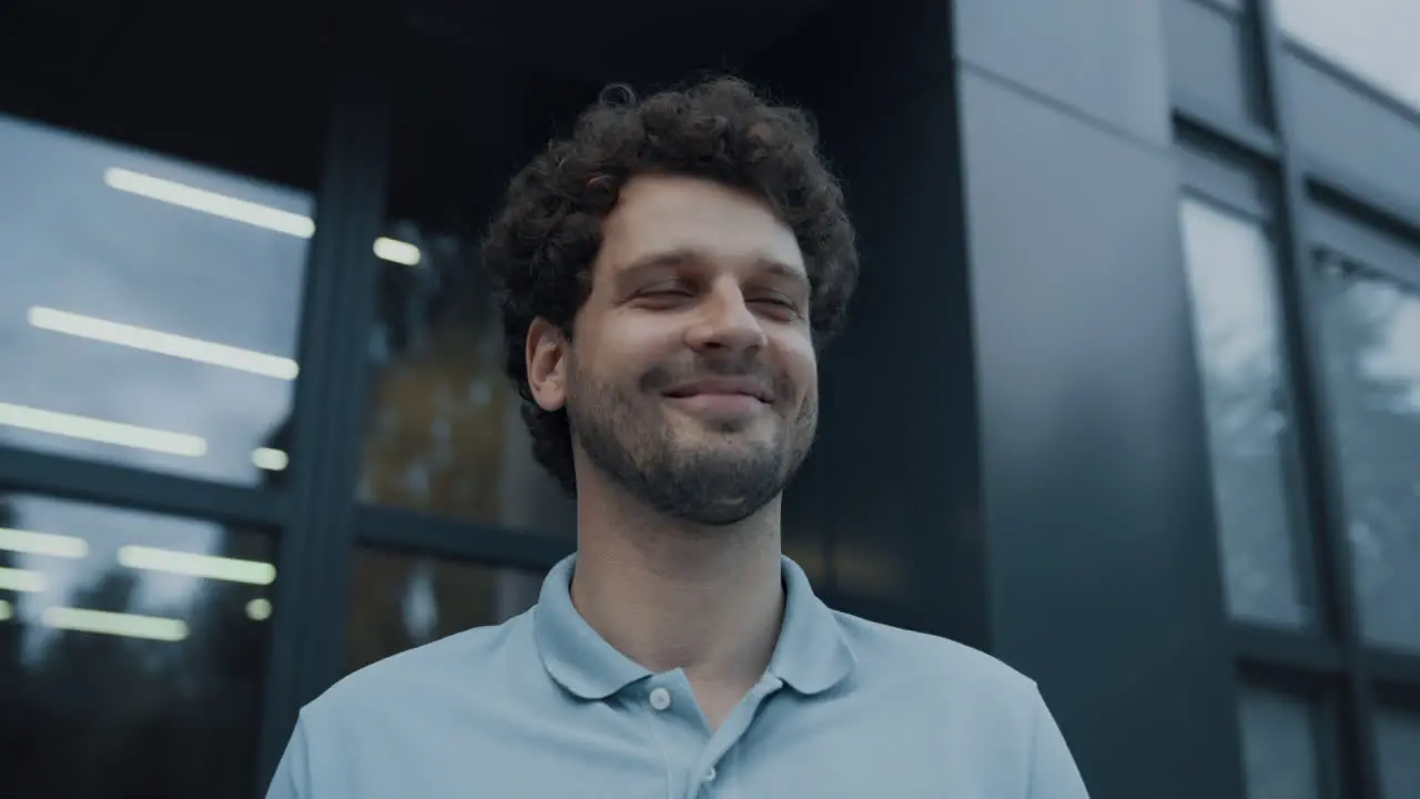 Closeup smiling man teacher standing at school entrance looking distance