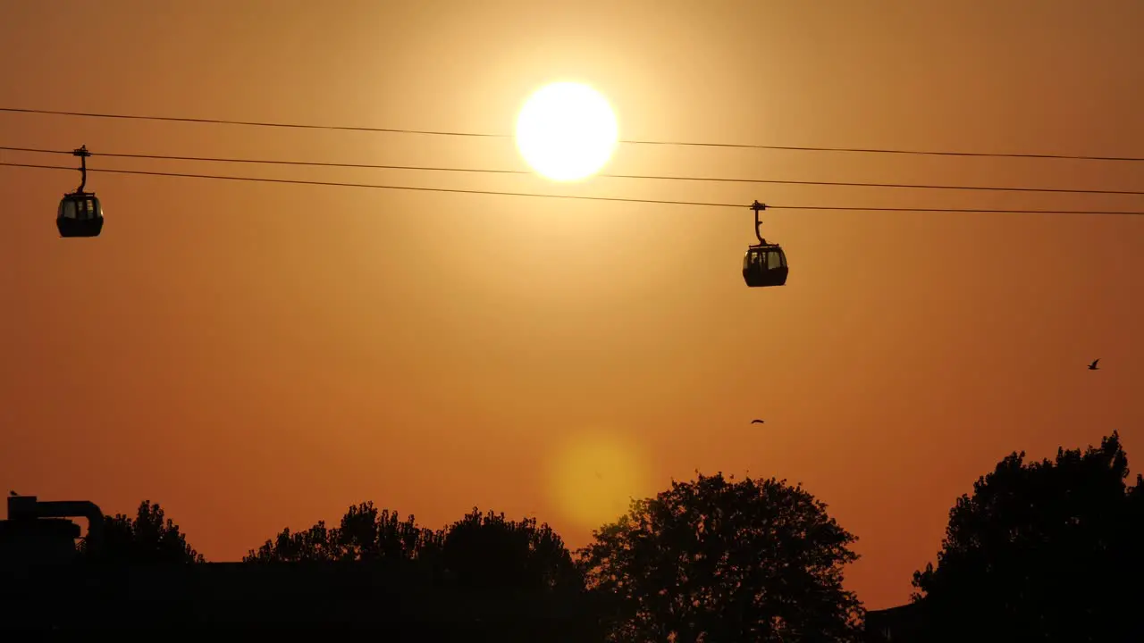 Gondola Cableway passing by during Sunset with orange red evening Sky and Sun in Constanta Romania