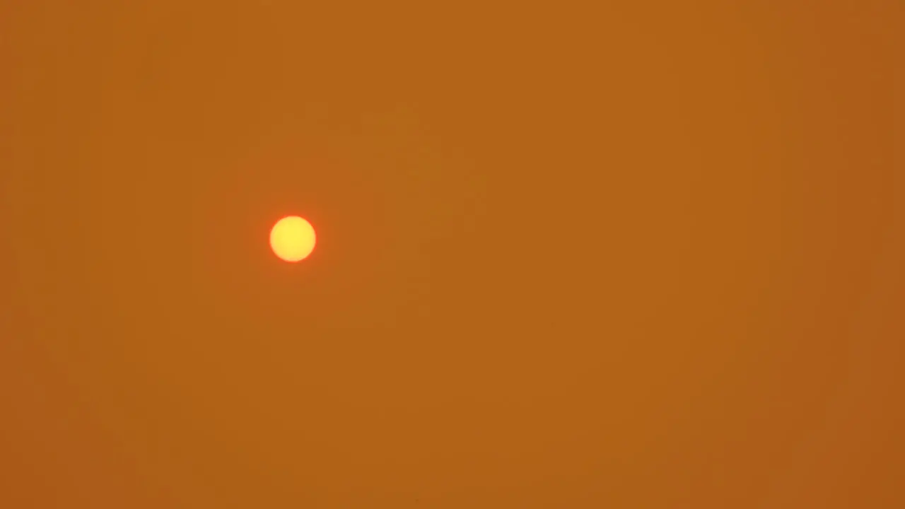 Orange Sun in Smokey Orange Sky as Ash Settles on Lens