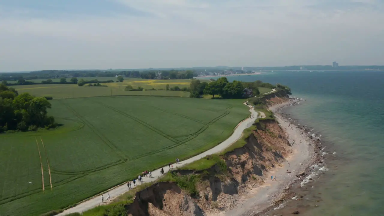 Peaceful scenery in Brodten Germany aerial drone view of beach shoreline coast facing Baltic sea with vast green spring field dolly in day