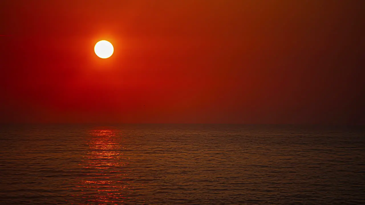 Shot of sunrise over calm sea at dawn over horizon in timelapse