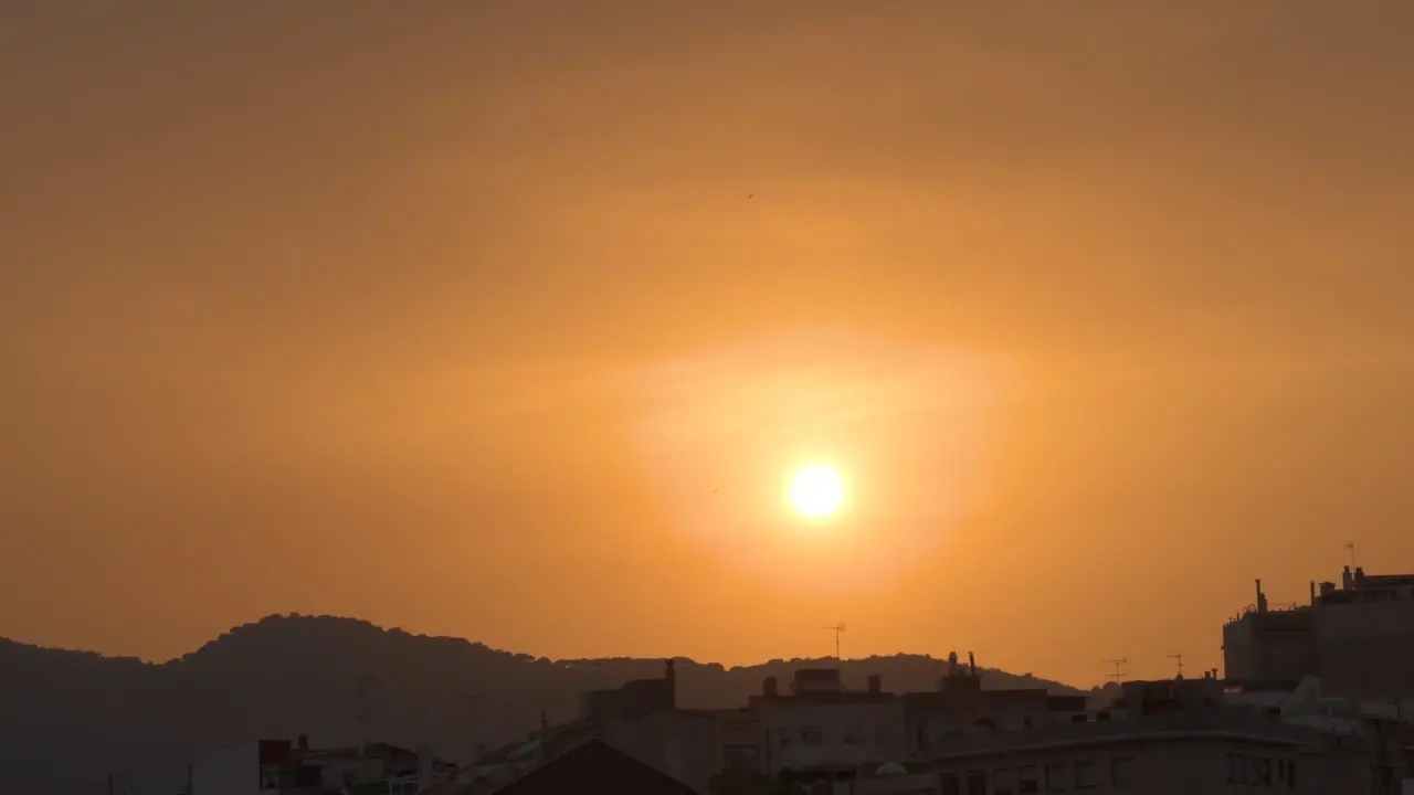 Beautiful sunset over the city with the mountains in the background and the orange sky