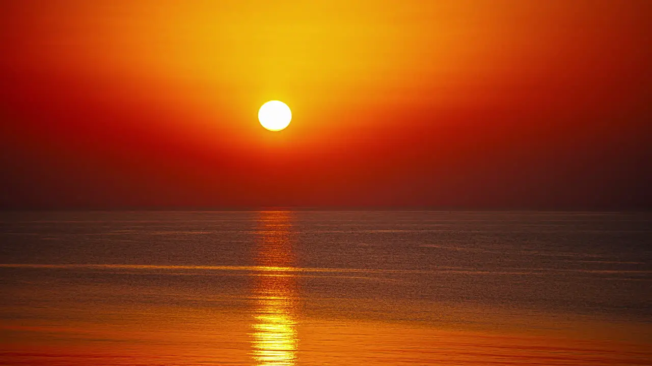 Time lapse shot of orange sun ball going down at horizon of ocean Golden sunset at sea