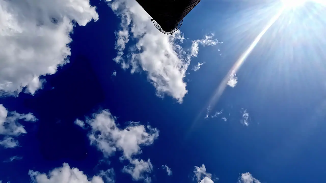 Low angle shot of sun movement along dramatic cloudy sky with white cumulus cloud movement in timelapse