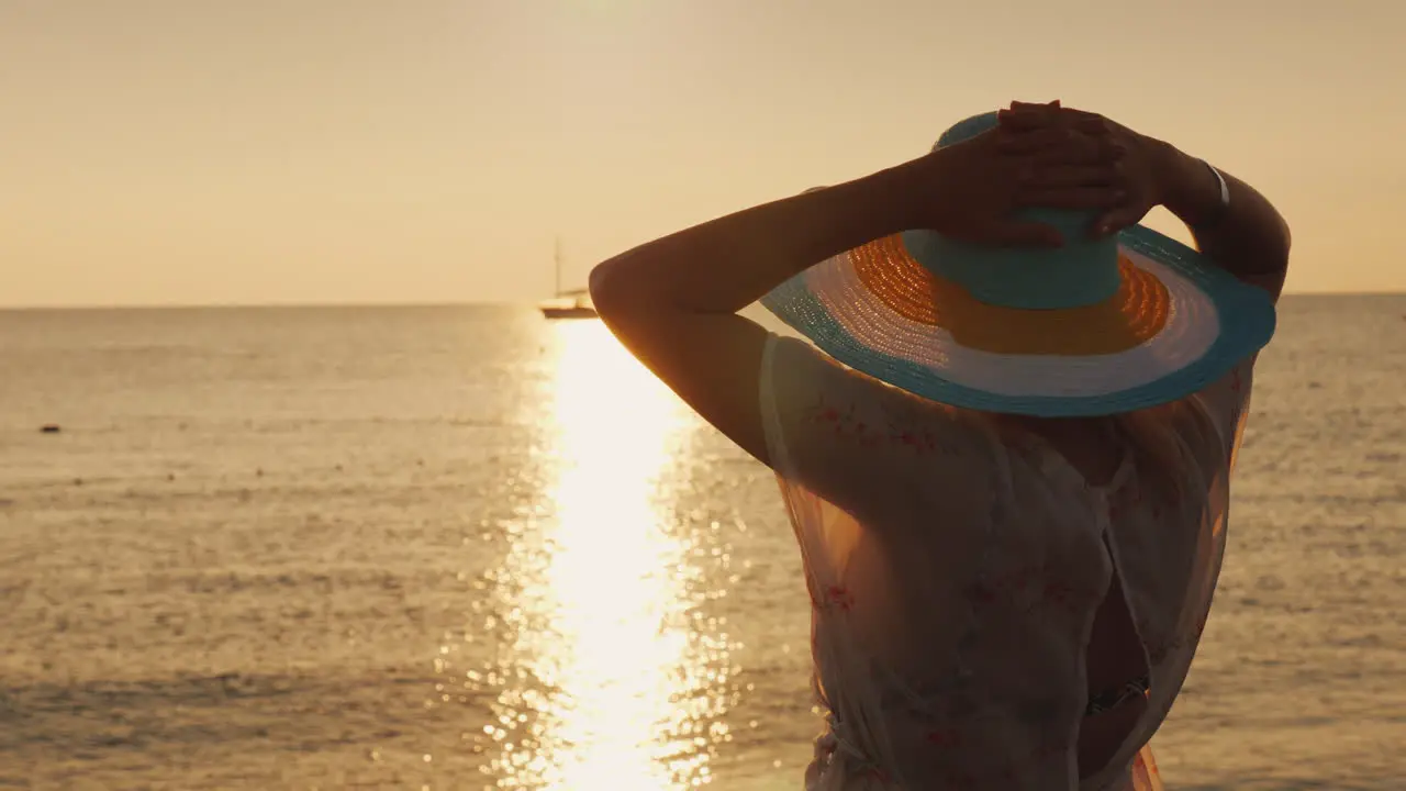 A Woman In A Hat Is Looking Forward To The Dawn Over The Sea Holiday And Vacation Concept