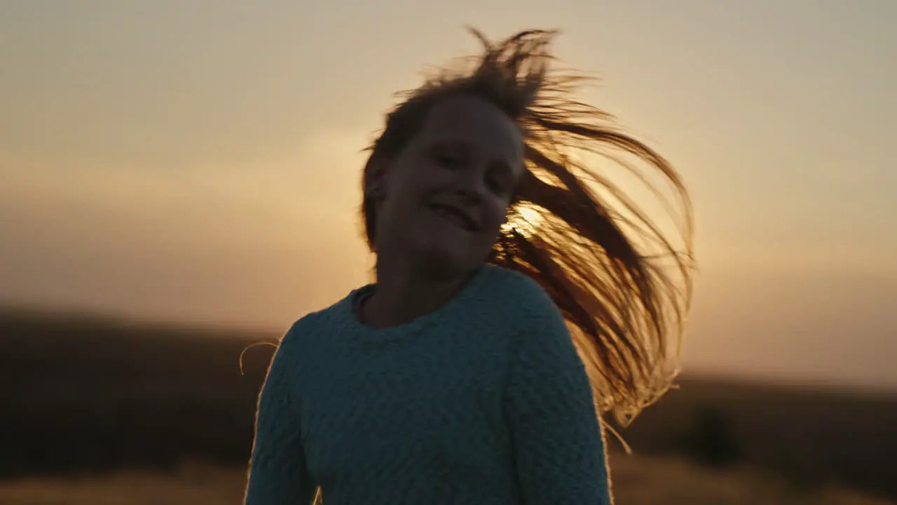 Carefree child waving her long hair in the sun